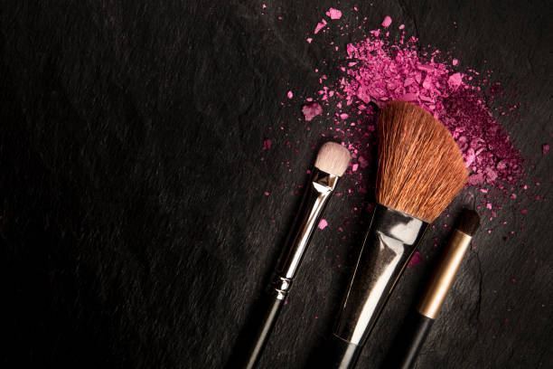 istock Make-up brushes with crushed cosmetics, shot from the top on a black background with copy space, a beauty design template for a makeup banner 1176567636