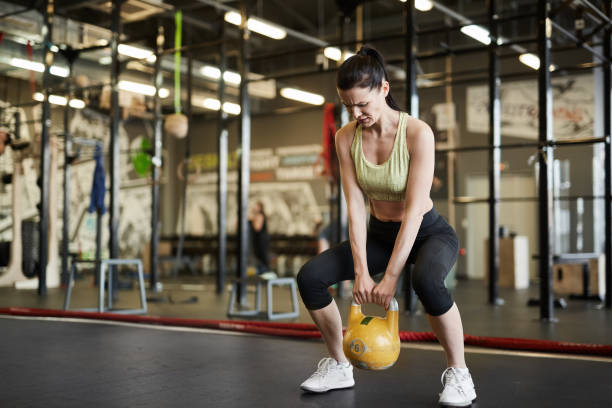 istock Strong Woman Lifting Weights 1176569482
