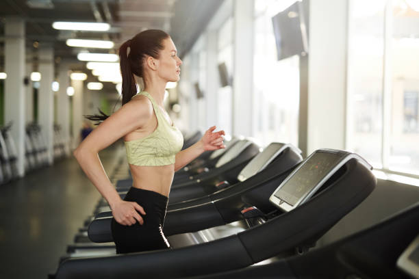 istock Woman Running on Treadmill in Gym 1176569716