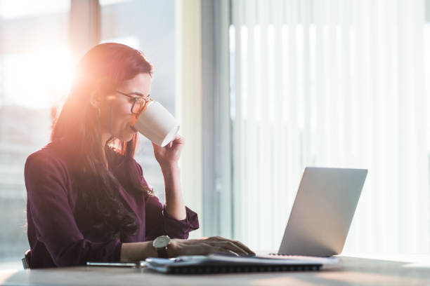 istock Businesswoman drinking coffee and working in modern office. 1176570894