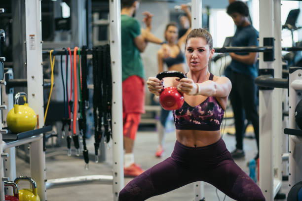 istock Young woman doing kettlebell exercise at gym 1176571181