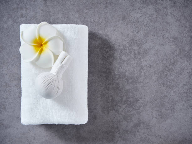 schönes spa mit kräuterkompresse kugel auf grauem marmor hintergrund. - massaging spa treatment stone massage therapist stock-fotos und bilder