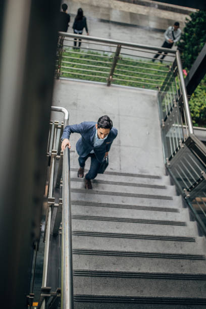 istock Handsome businessman walking up the steps downtown in Taipei 1176573319