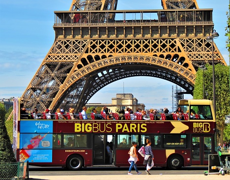 Paris, France - September 06, 2019. People on Paris Hop-on Hop-off Bus Tour visiting the Eiffel Tower.