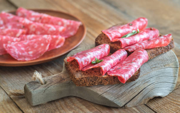 Sandwiches with salami on the wooden board Sandwiches with spanish salami on the wooden board sliced salami stock pictures, royalty-free photos & images