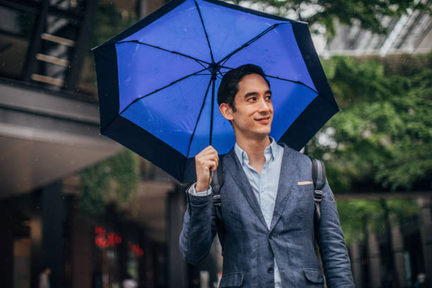 istock Modern man with blue umbrella in city 1176574894