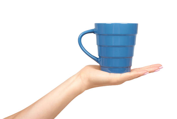 Hand with blue ceramic cup, mug for coffee and tea, kitchen pottery.