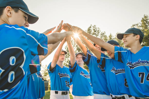 Group of baseball players standing together on the playground with hand over A Group of baseball players standing together on the playground men baseball baseball cap baseball bat stock pictures, royalty-free photos & images