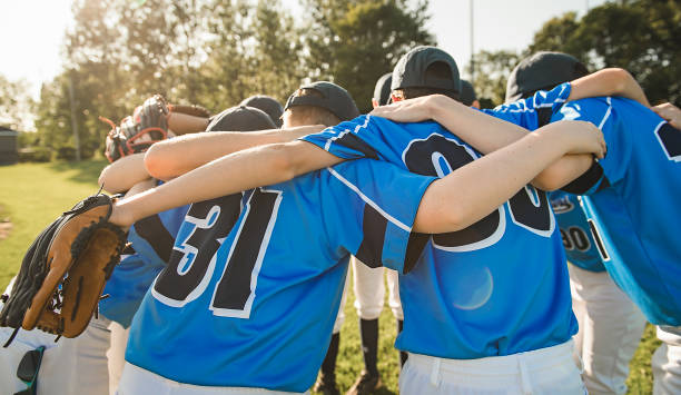 Group of baseball players standing together on the playground A Group of baseball players standing together on the playground men baseball baseball cap baseball bat stock pictures, royalty-free photos & images