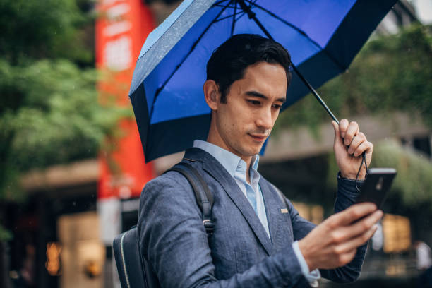 istock Modern gentleman with blue umbrella in city 1176575598