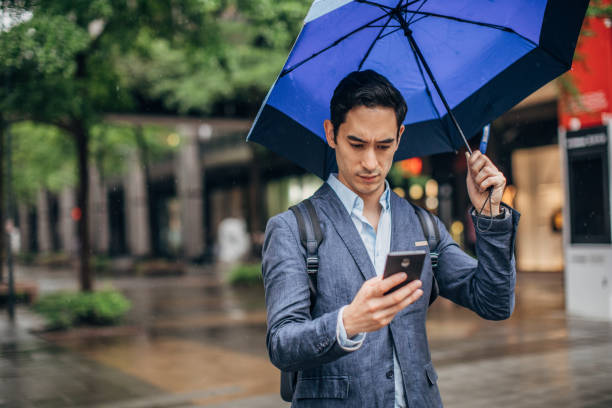 istock Modern man with blue umbrella in city 1176575709