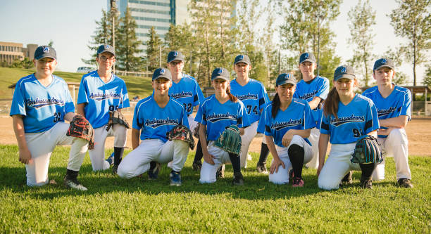 gruppe von baseballspielern, die zusammen auf dem spielplatz stehen - baseballmannschaft stock-fotos und bilder