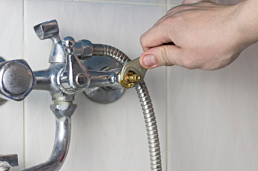 A man is repairing a water tap, a close-up