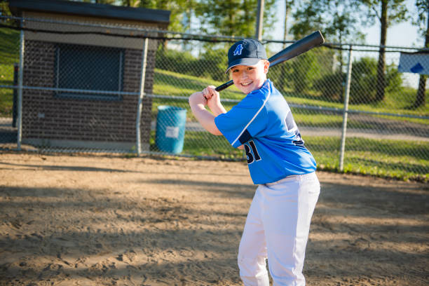 un niño jugador de béisbol sosteniendo bate en el patio de recreo - men baseball baseball cap baseball bat fotografías e imágenes de stock
