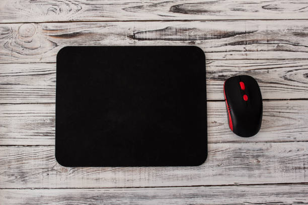 black computer mousepad with a mouse on a white wooden background - mouse pad imagens e fotografias de stock