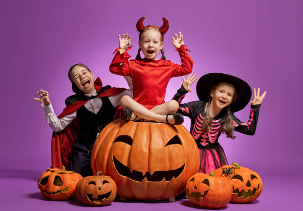 istock little witch, Dracula and pumpkin on purple background 1176578582