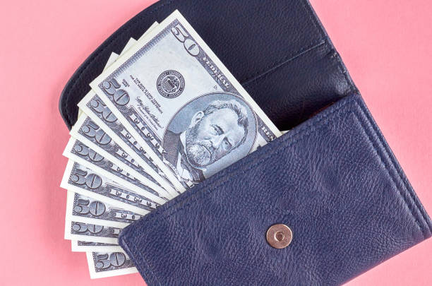 istock Dark blue leather wallet with money on pink background composition. 1176578908