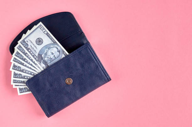 istock Dark blue leather wallet with money on pink background composition. 1176578914
