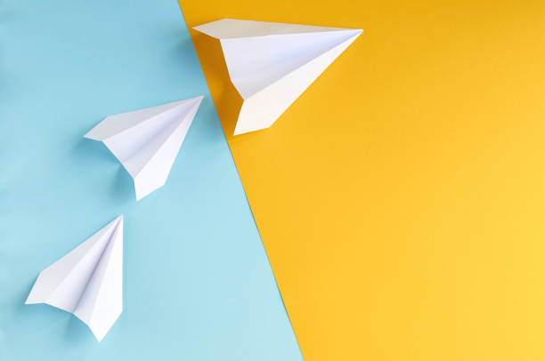 istock White paper planes on blue and yellow background composition. 1176579294