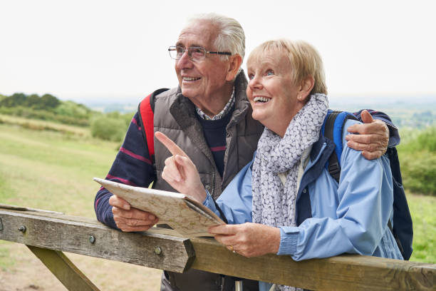 istock Retired Senior Couple On Walking Holiday Resting On Gate Looking At Map 1176581591