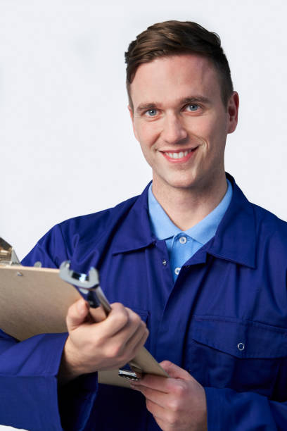 istock Studio Portrait Of Male Engineer With Clipboard And Spanner Against White Background 1176582097