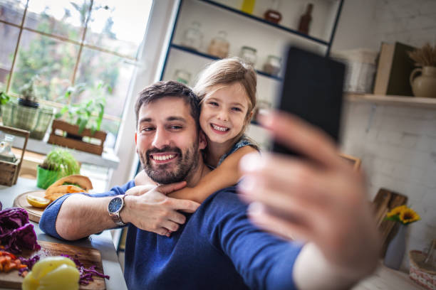 istock Father and daughter taking selfie in the kitchen 1176582133