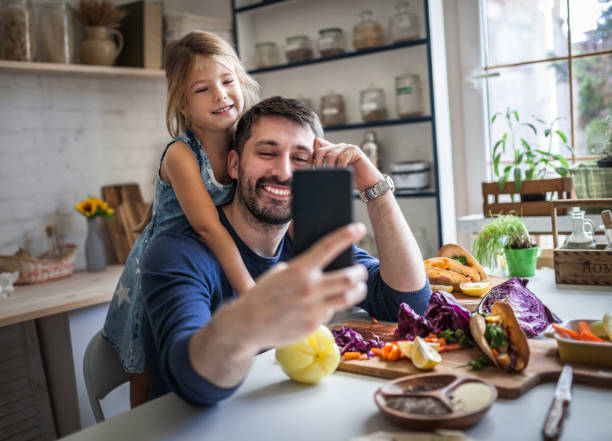 istock Father and daughter taking selfie in the kitchen 1176582136