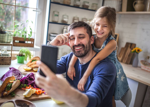 istock Father and daughter taking selfie in the kitchen 1176582383