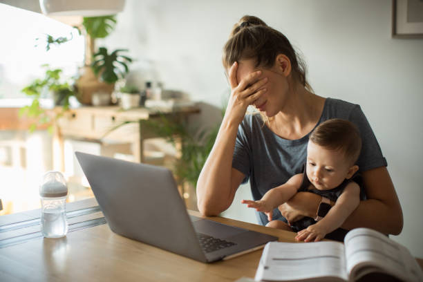 Online consultation. Mother and son sitting at the table with laptop. Mother is consulting online. Looking sad and frustrated. information overload photos stock pictures, royalty-free photos & images