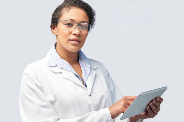 Studio Portrait Of Female Laboratory Technician Working With Digital Tablet Studio Portrait Of Female Laboratory Technician Working With Digital Tablet african american scientist stock pictures, royalty-free photos & images