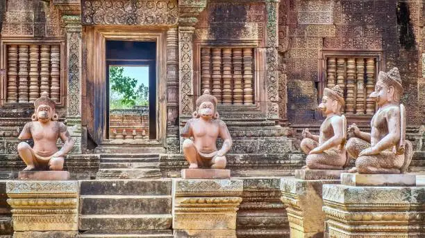 Statues of human figures with animal heads at the entrance to the 10th century Banteay Srei temple at Angkor Wat in Siem Reap, Cambodia. These are replicas to replace damaged, vandalized or stolen originals.