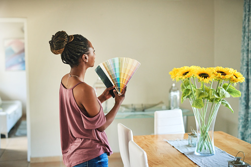 Shot of a young woman fanning out color swatches at home