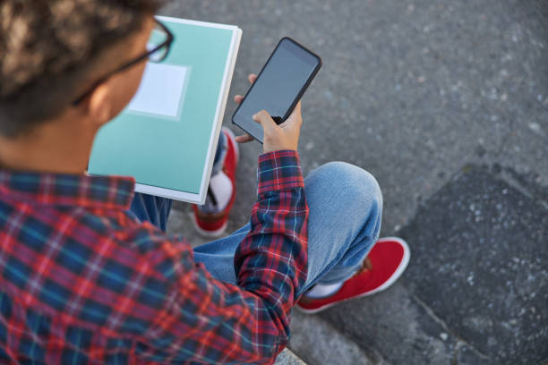 istock Young guy in glasses is sitting outdoors 1176589180