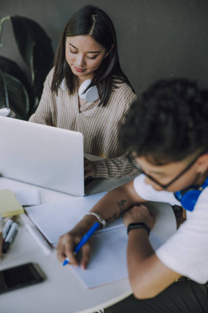 istock Young calm girl working with her classmate at table 1176591115
