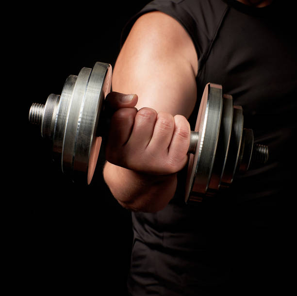 istock hand of a man with big biceps holds a steel type-setting dumbbell 1176593166