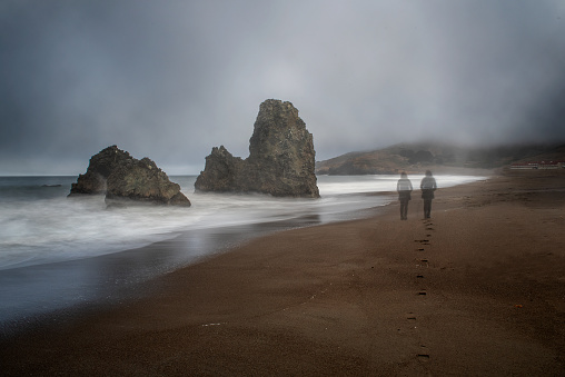 Sometimes I am twor: two ghosts at Rodeo Beach, California, USA, in San Francisco Marin Headlands recreation area , one set of footprints