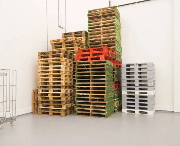 piled up pallets in a corner of a factory