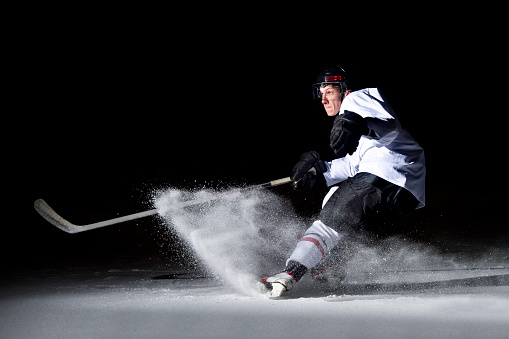 Jugador de hockey sobre hielo en acción kicking con palo photo