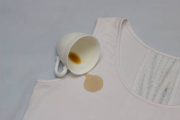 verschüttete kaffeetasse auf weißem hemd, kaffeefleck auf kleidung, nahaufnahme, tasse, fleckenentferner - coffee cup flash stock-fotos und bilder