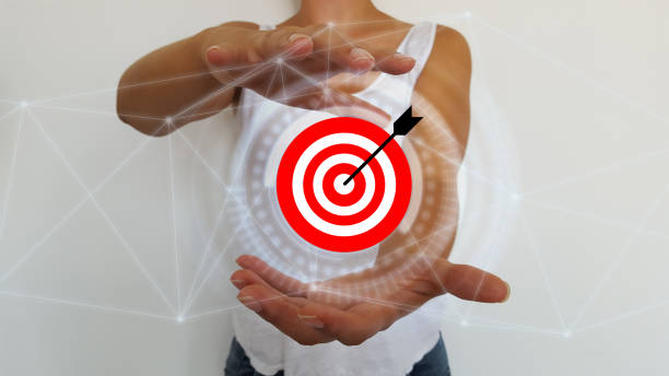 istock Bussinesswoman holding in hands target and arrow with digital interface 1176599438