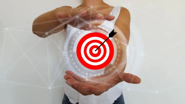 Bussinesswoman holding in hands target and arrow with digital interface
