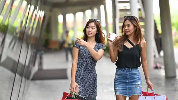 Young shopping friends walking on resort shopping mall, Black Friday Holiday concept.