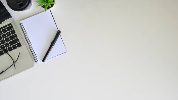 istock Office desk laptop, coffee, pen and diary with glasses, copy space table. 1176600432