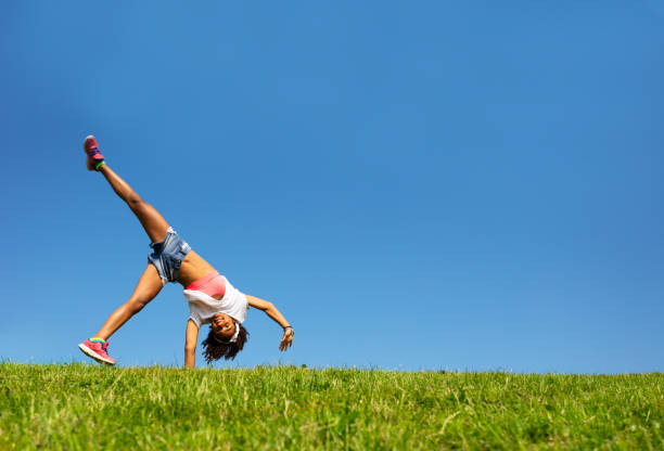 istock Happy girl walk on hands over blue sky and grass 1176600675