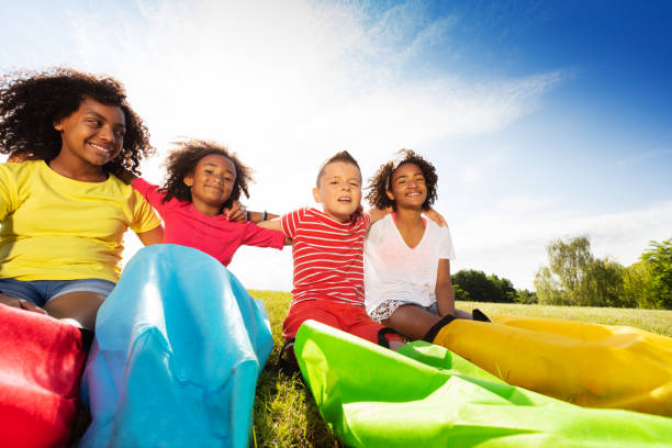 istock Group of kids sit with race sacks on the lawn 1176600854