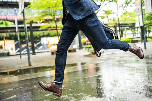 Unrecognizable businessman running to work, low angle view of his pants and shoes