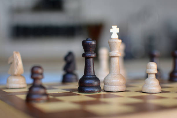 istock Chess board game with focus on black and white queen pieces on blurry 1176602582