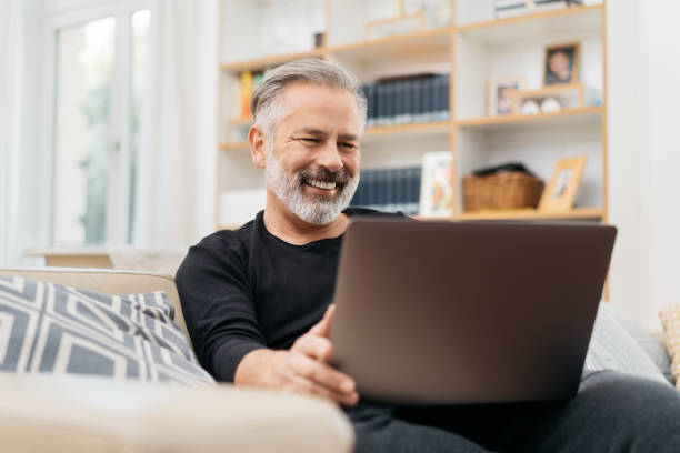 istock Middle-aged man watching a funny video on laptop 1176603333