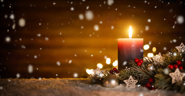 Candle and Christmas decoration with wooden background and snow stock photo