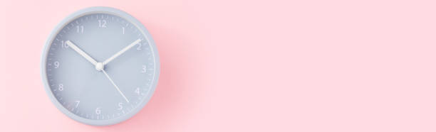 istock Gray alarm clock on a pink background with copy space, top view, long banner 1176604877